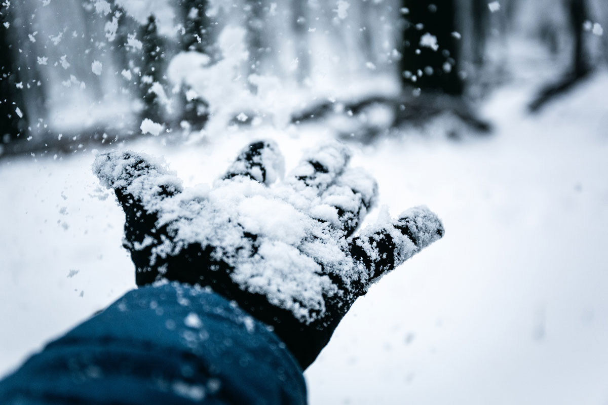 gloved hand catching snow in winter